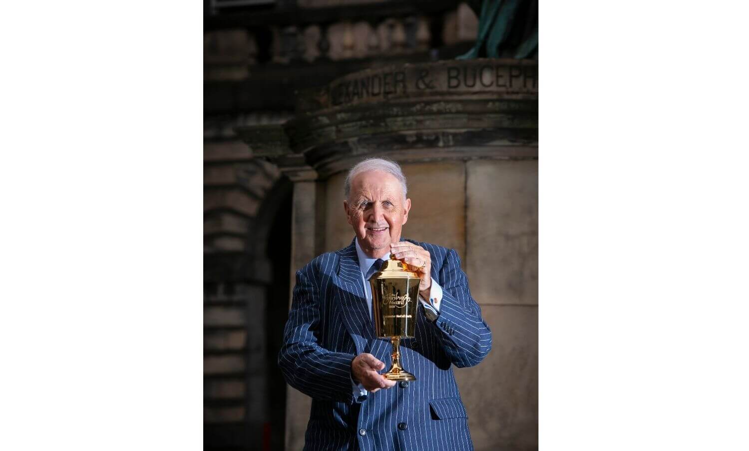 Alexander McCall smith holding the Edinburgh Award Loving Cup in the City Chambers Quadrangle.