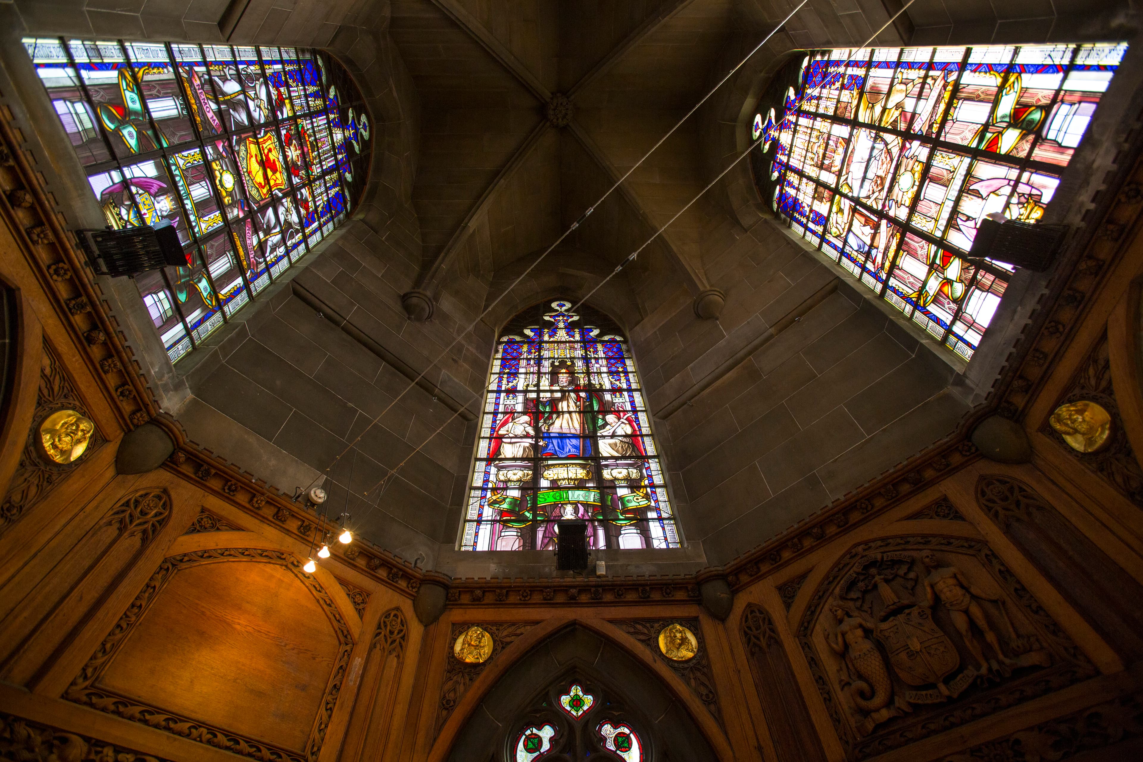 The grand interior of the Scott Monument adorned with beautiful stained glass windows, showcasing vibrant colors and detailed designs.