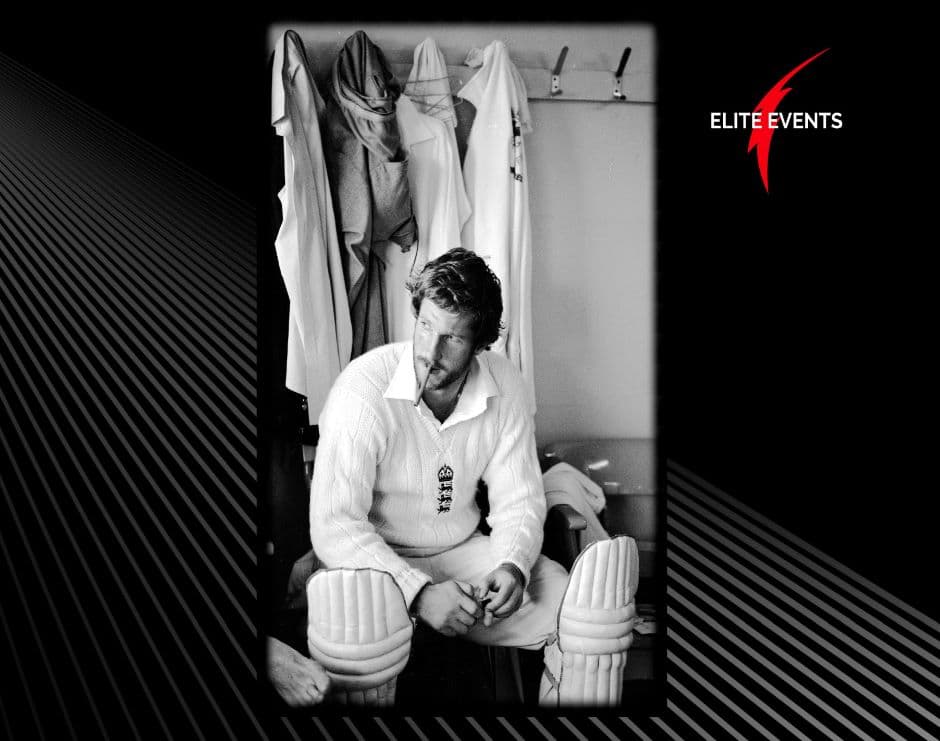 Black and White photo of Ian Botham wearing criket uniform sitting in a changing room 