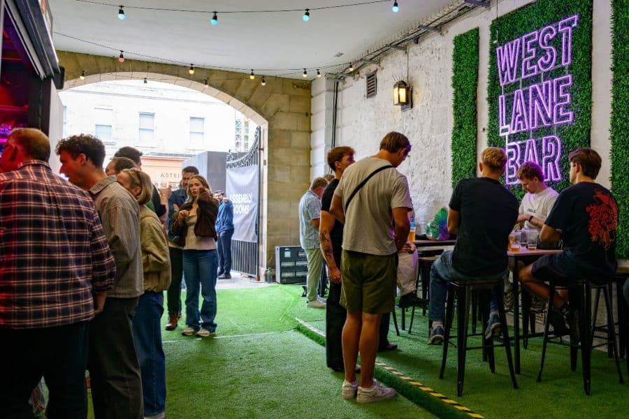 Vibrant busy bar area with LED sign reading west lane bar
