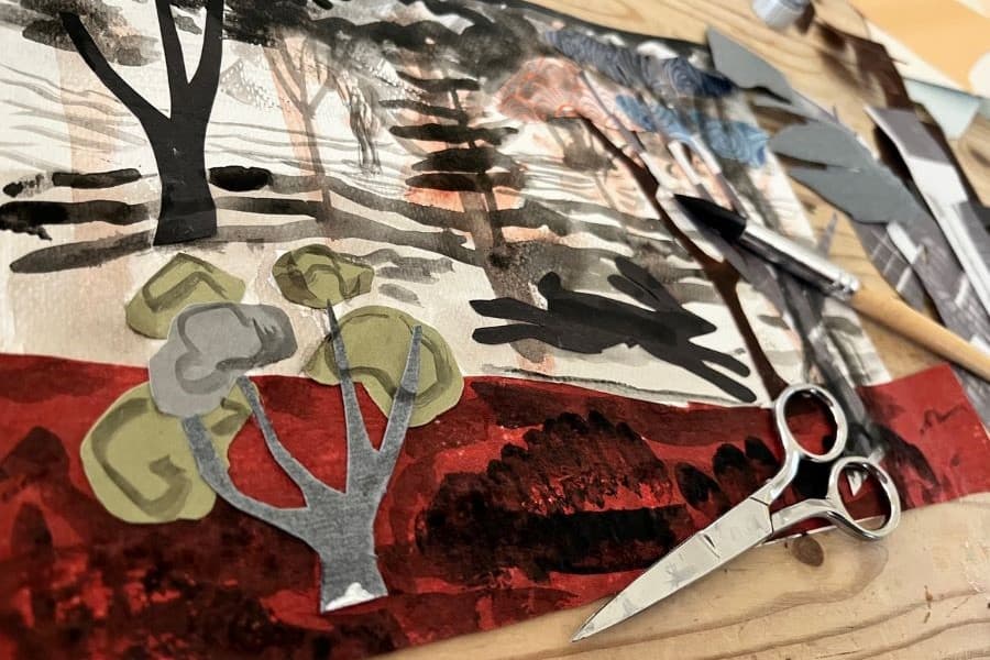 Photo of collage in the making with cut-out paper tree and scissors