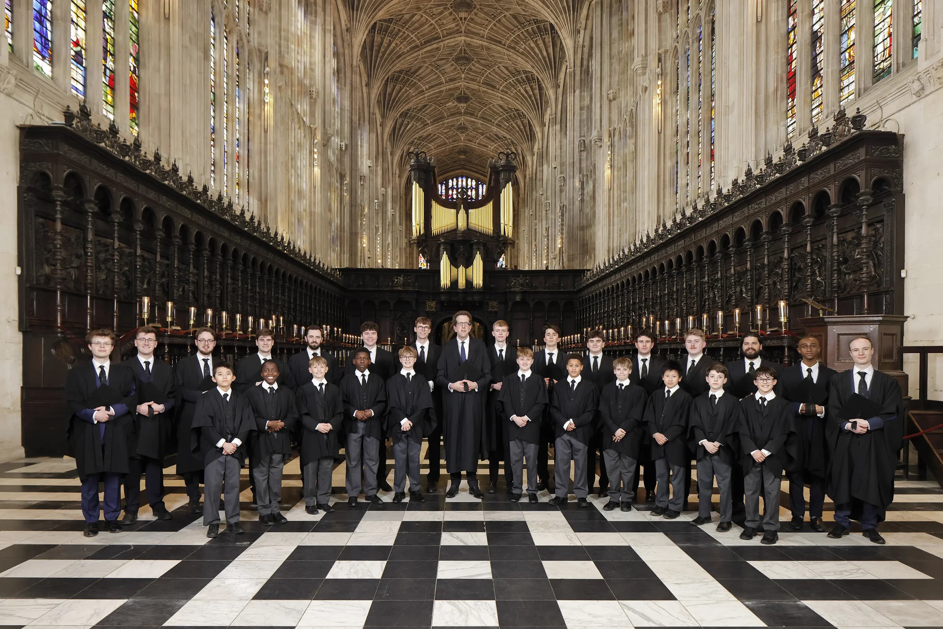 Choir of King's College, Cambridge dressed in black suits in a Church