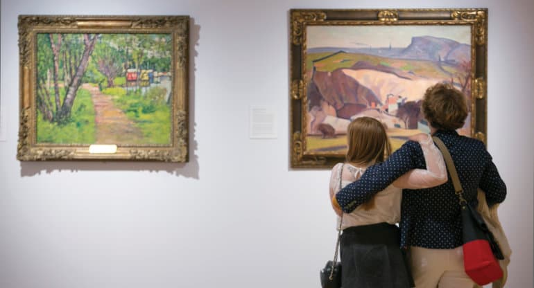 A mother and daughter admire two large paintings on an art gallery in the heart of Edinburgh.