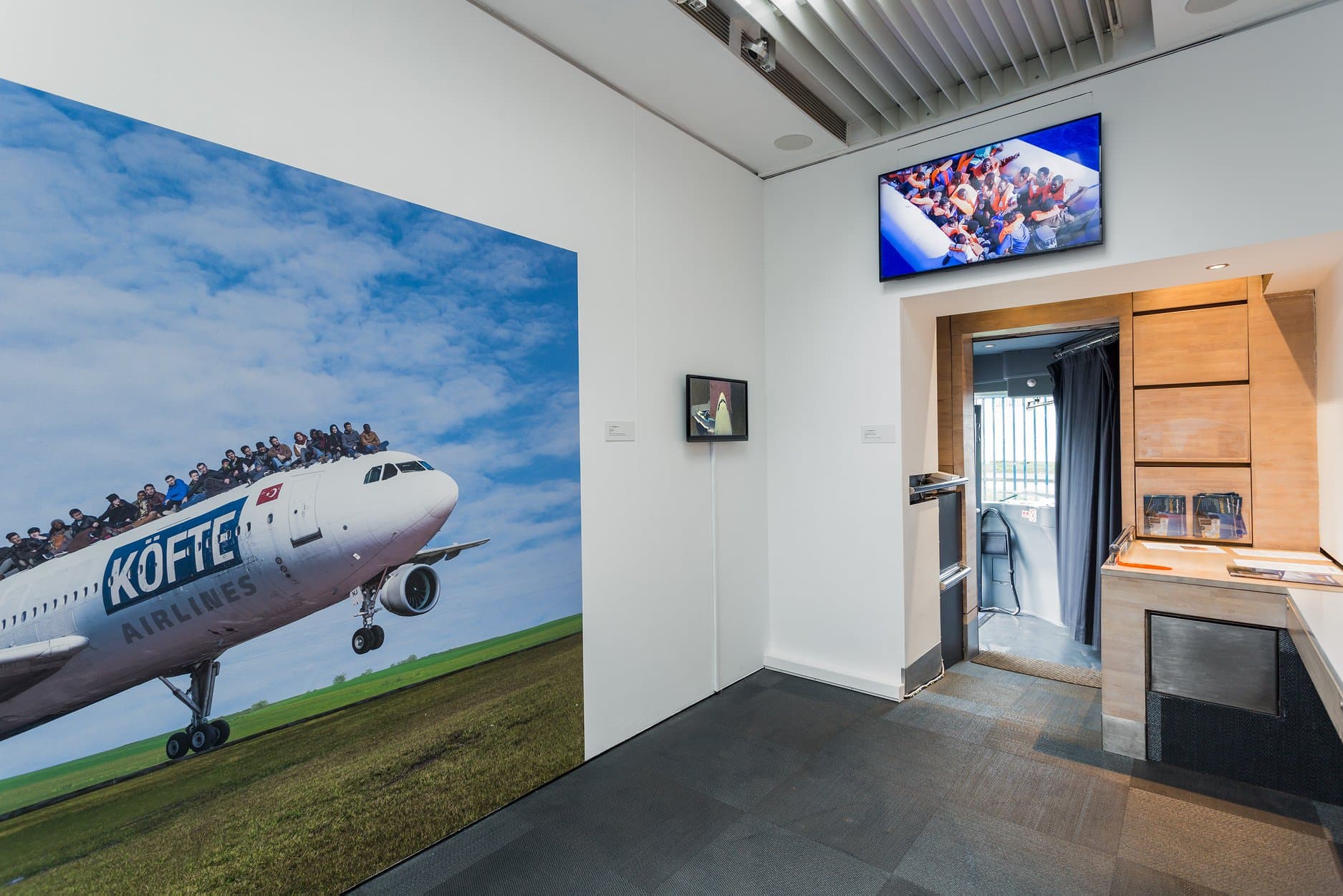 Displaced exhibition interior showing a picture of a plane