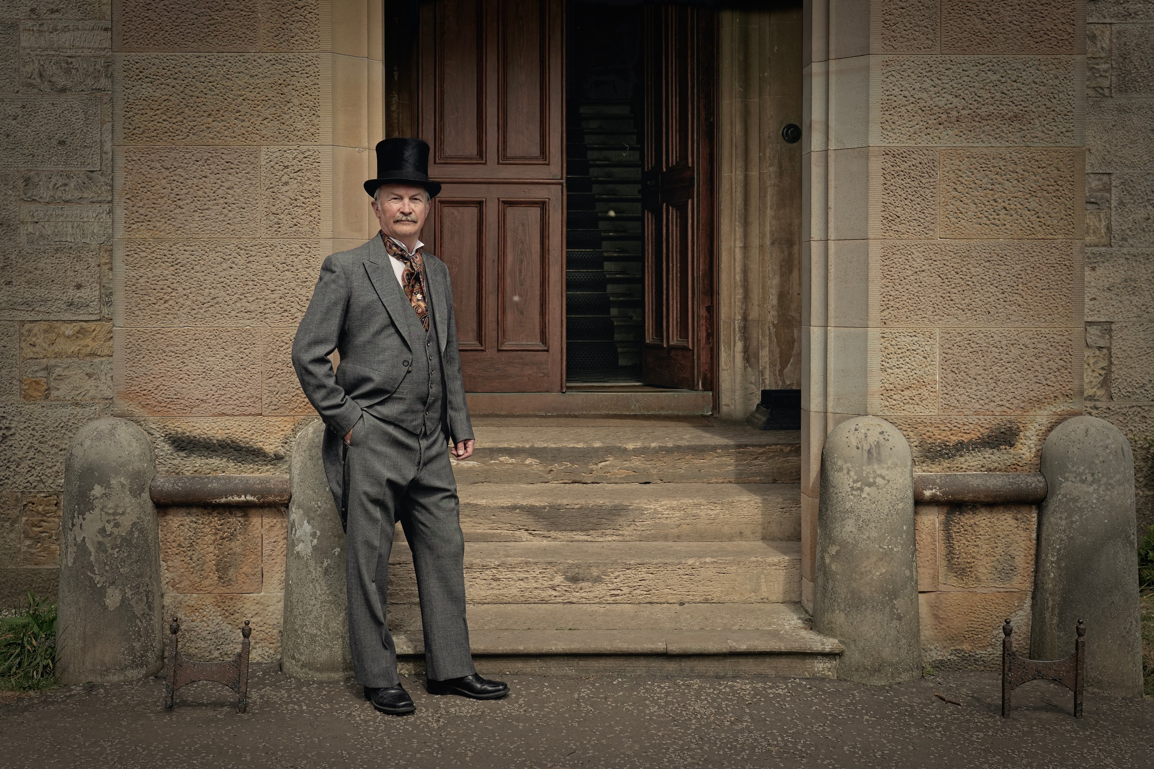 Man dressed in Edwardian costume standing at the entrance to Lauriston Castle