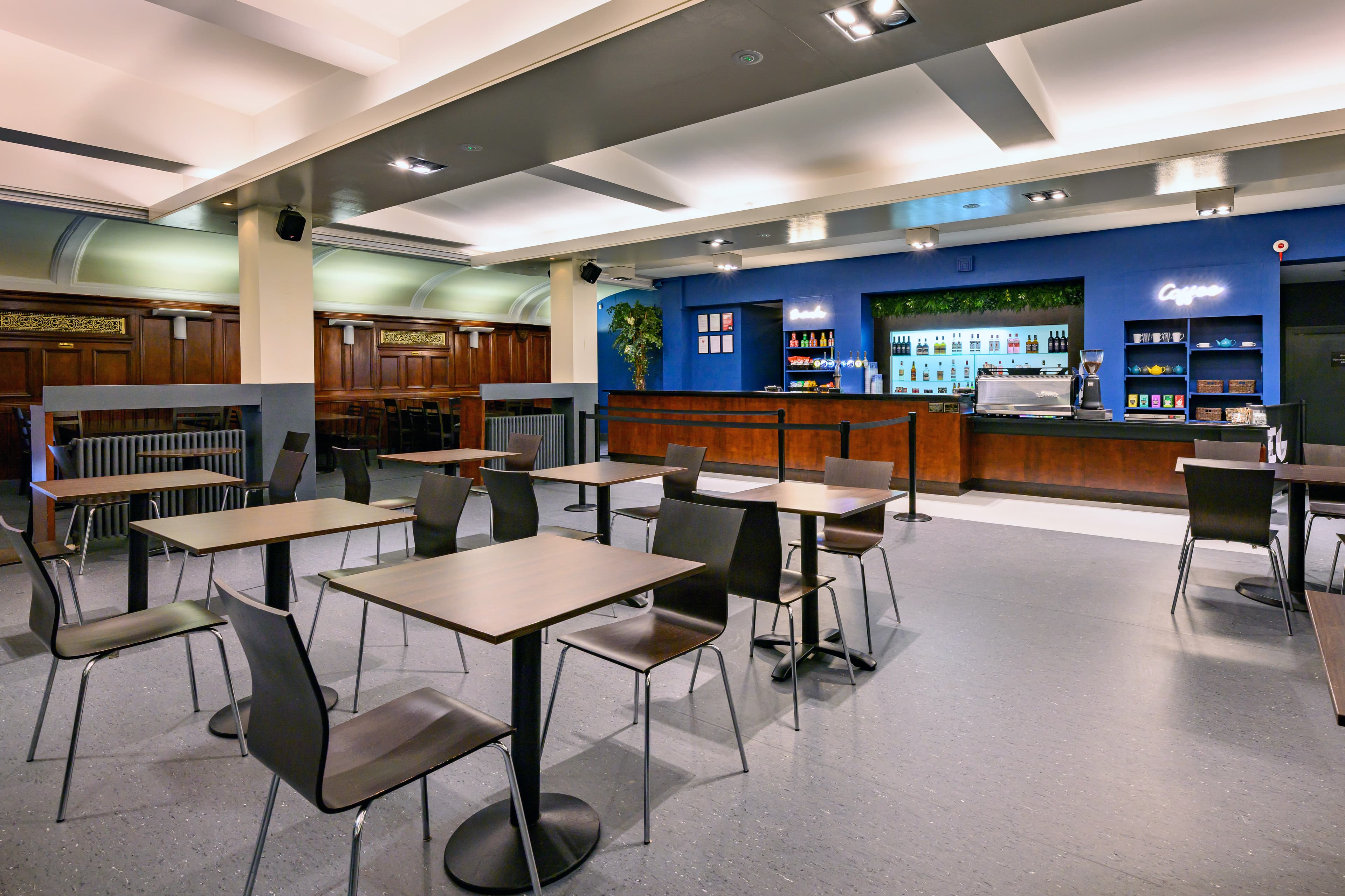 A spacious bar reception area with tables and chairs positioned centrally, creating a welcoming dining atmosphere.