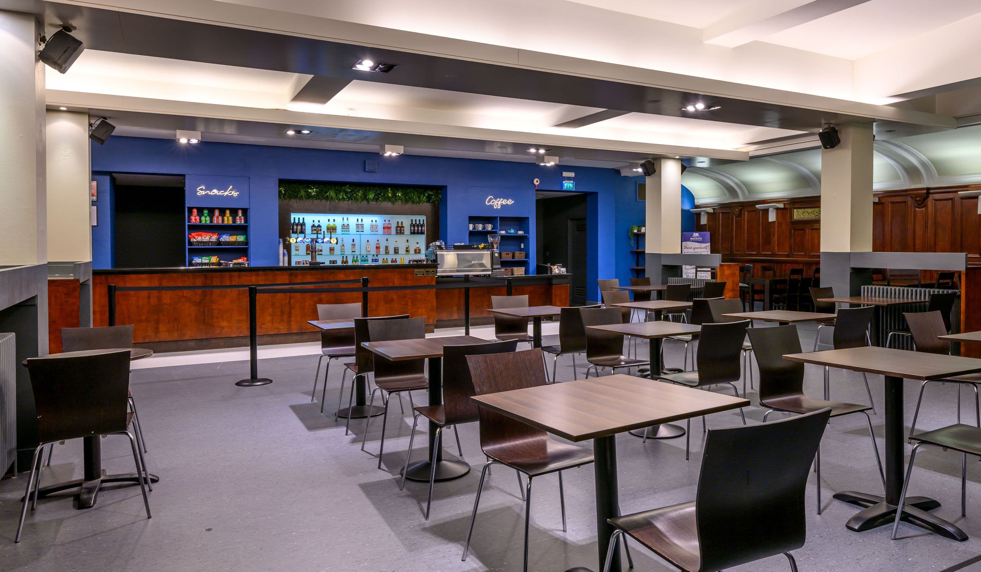 Church Hill Theatre's bar/cafe area with tables, chairs and a blue wall showing drinks