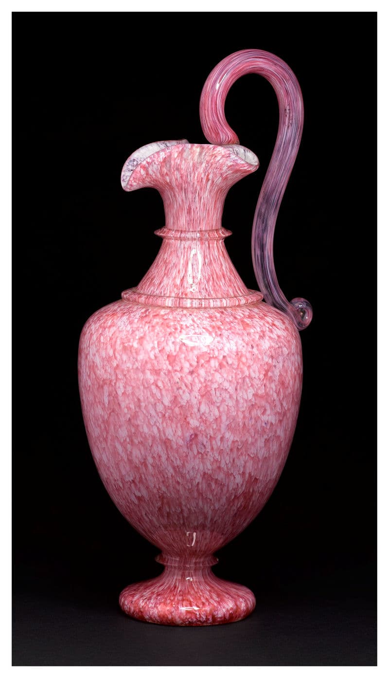 A pink glass vase featuring a pink handle and elegantly shaped