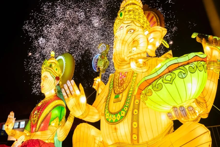 Two Golden light-up statues, one of an elephant and the other of a woman.