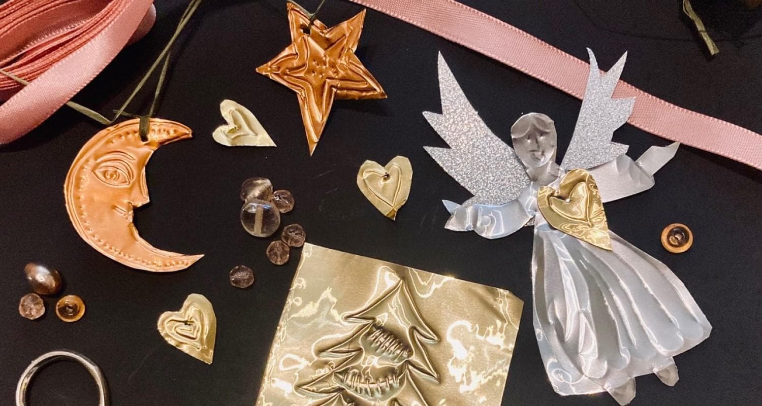 Festive Christmas ornaments and decorations in gold, silver and copper, scattered on a black surface