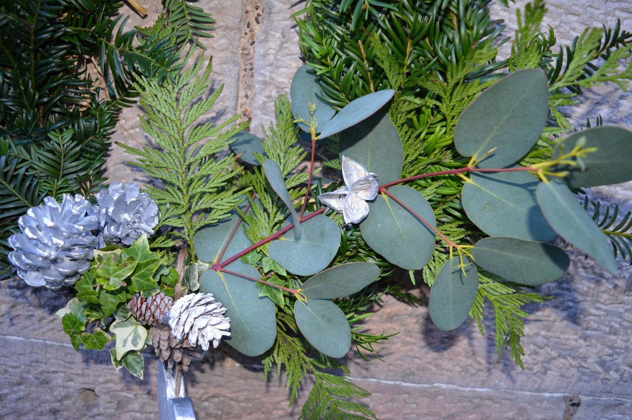 Image of a winter wreath with green follage and pine cones
