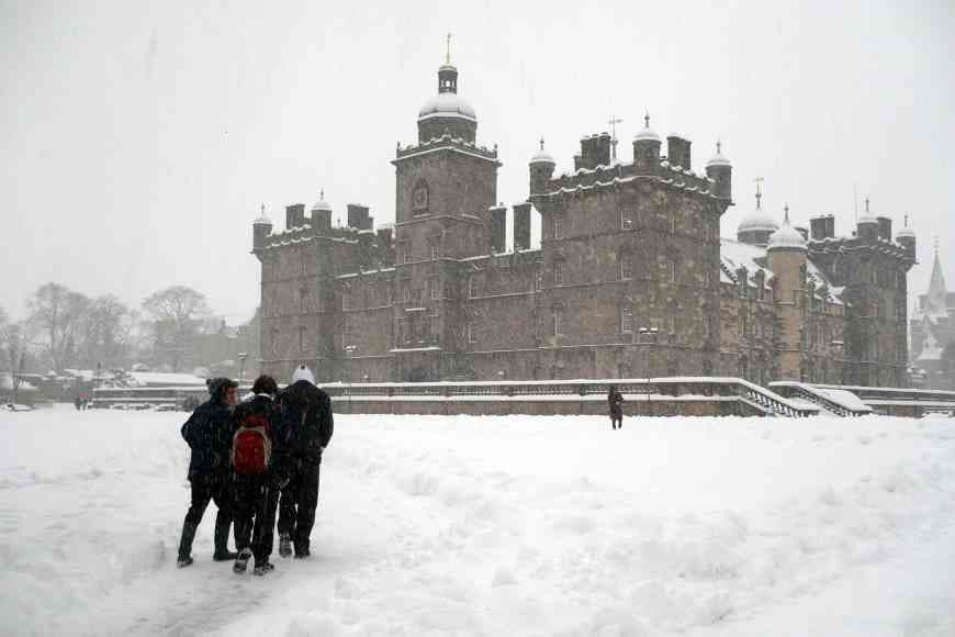 Photograph of George Heriot's School in Winter with a small group of people walking through the snow