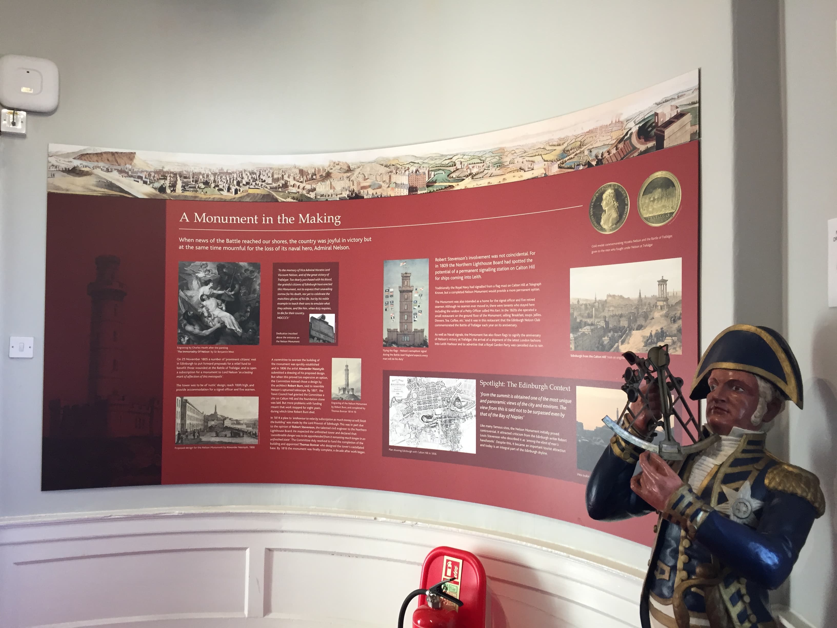 A statue depicting a man in uniform stands adjacent to a display, representing a moment in history or military service.