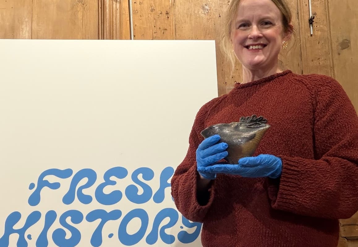 curator holding piece from the exhibition