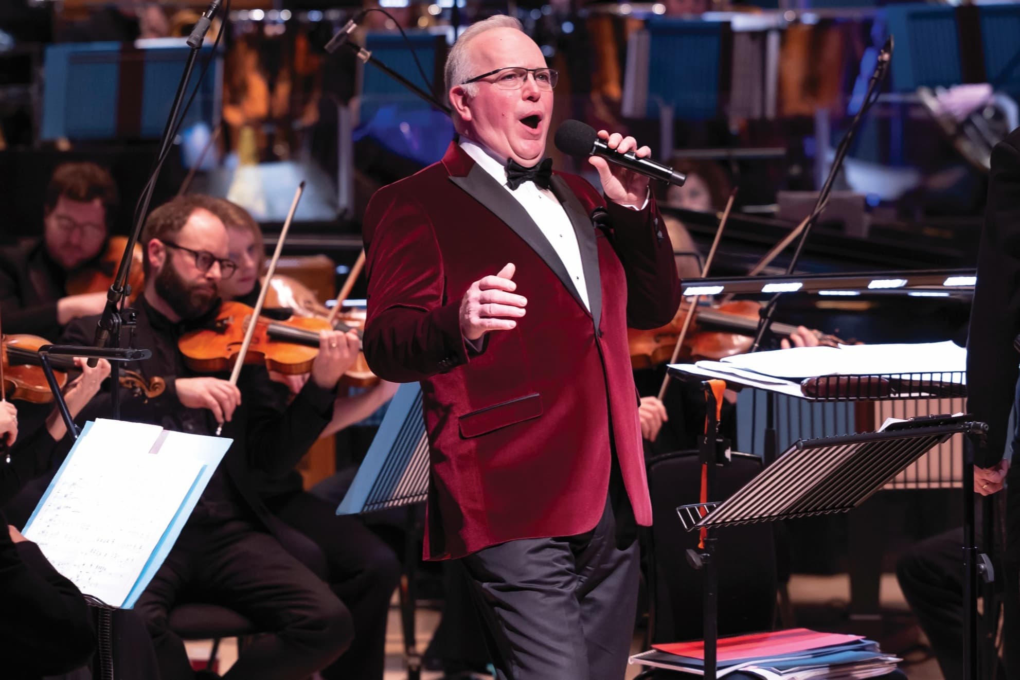 Jamie Macdougall on stage singing into a microphone