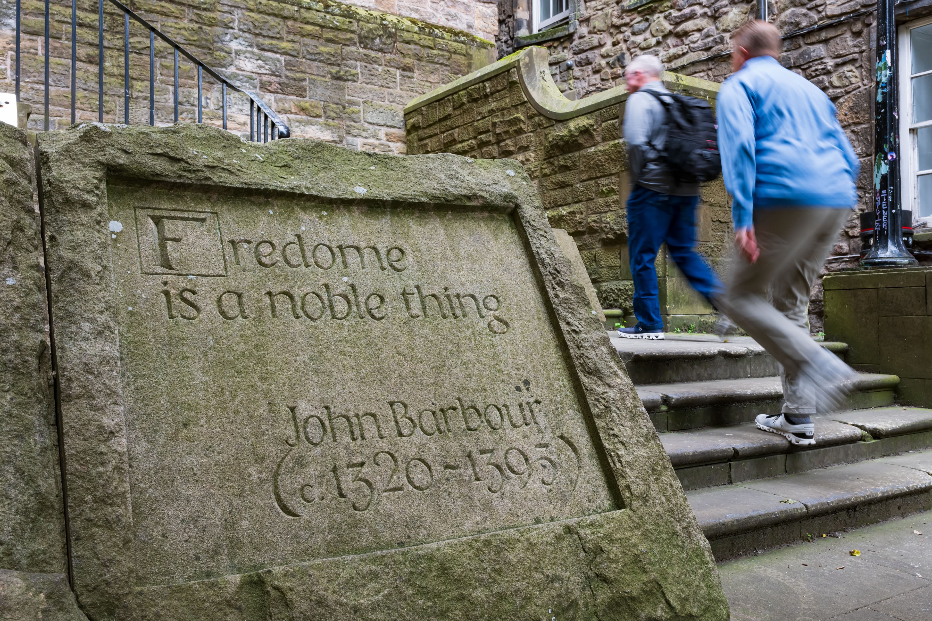 A stone plaque featuring the inscription "Freedom is a noble thing," symbolizing the significance of liberty. Displayed at the start of Makars Court area.