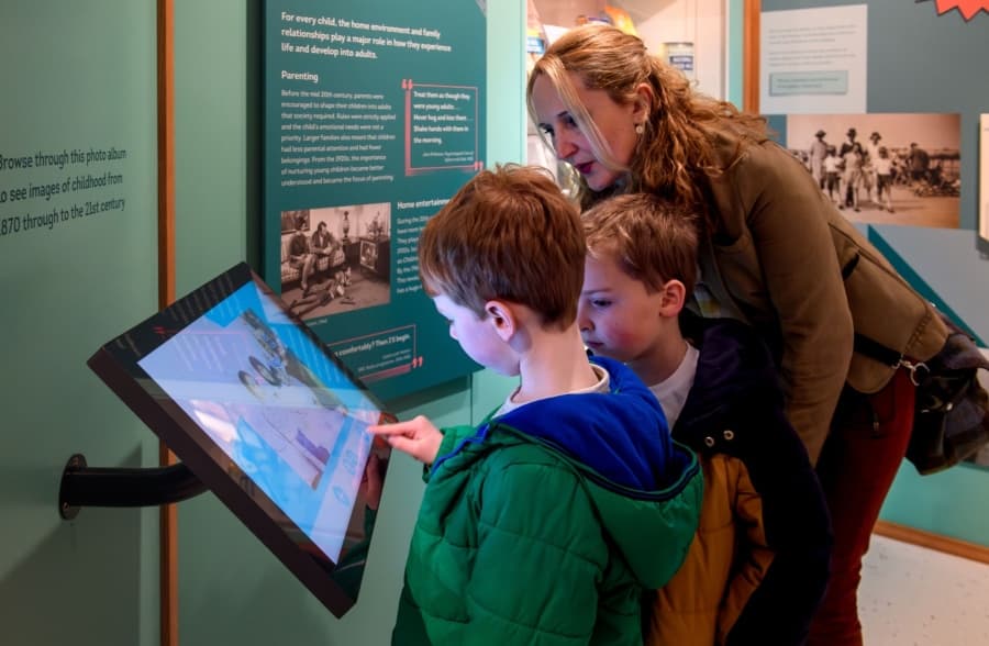 Mother and sons looking at interactive screen in Edinburgh's Museum of Childhood