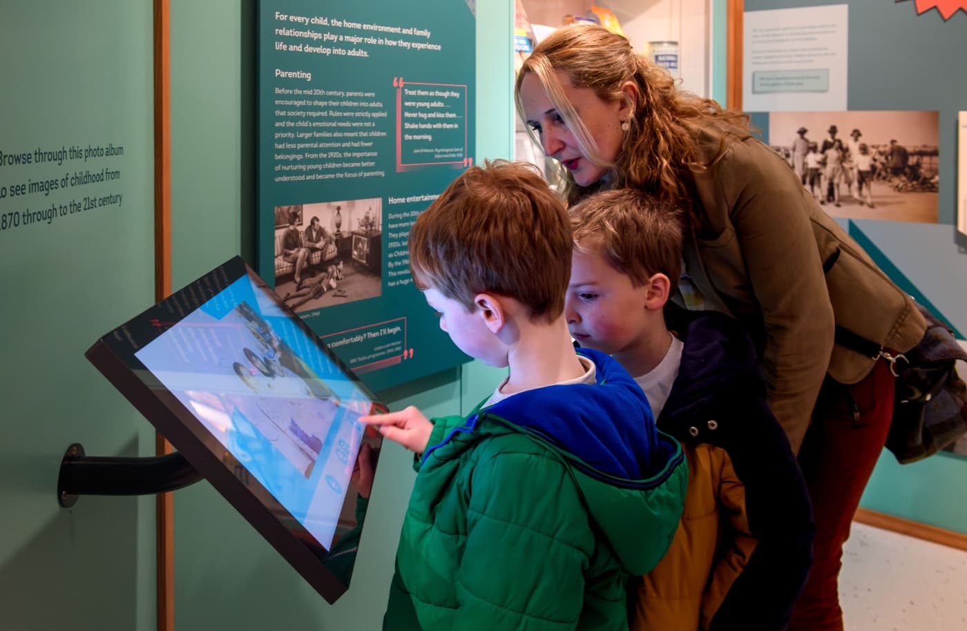Mother and sons looking at interactive screen