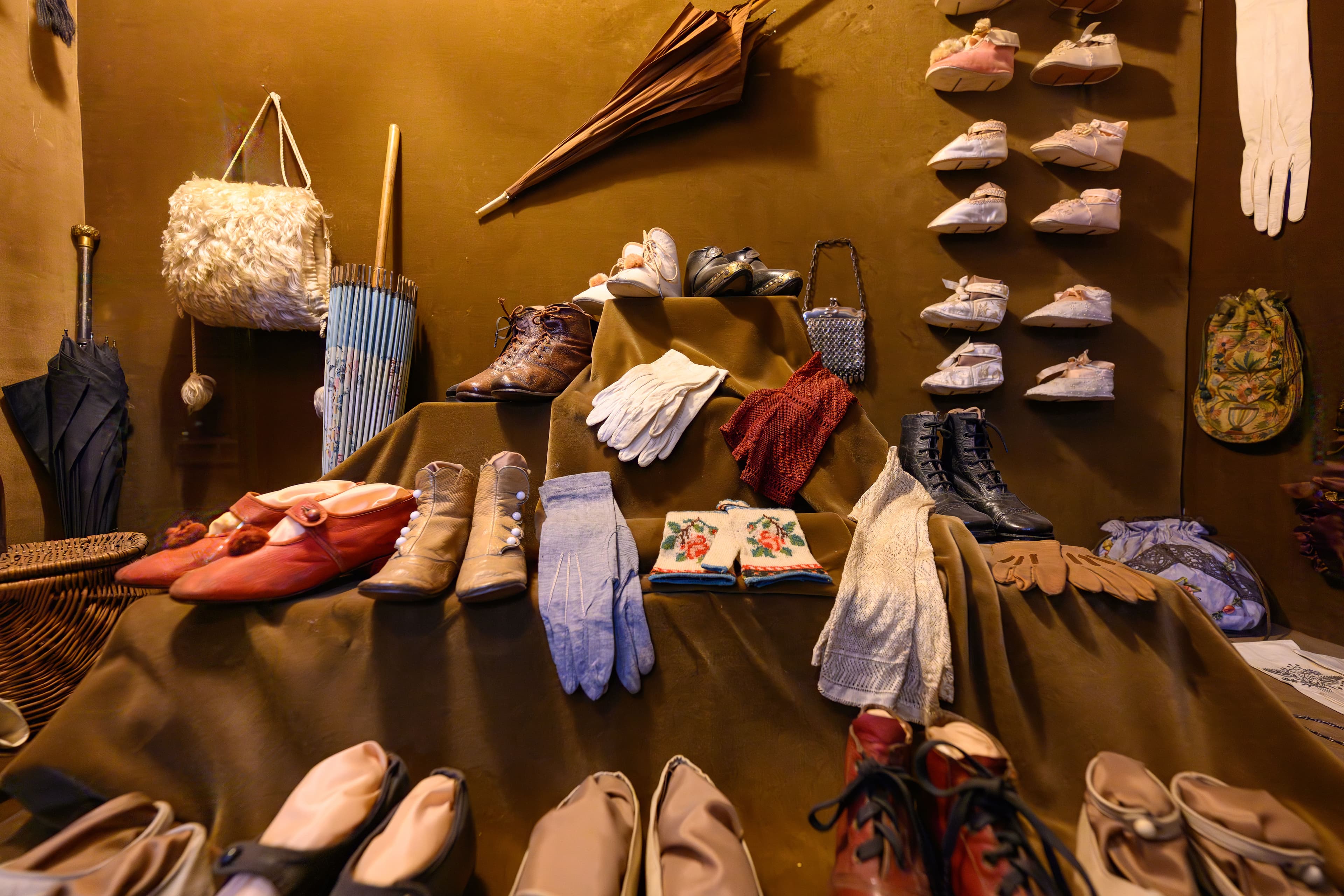 A collection of vintage shoes, hats, gloves, and additional accessories artfully arranged for display in a retail setting.