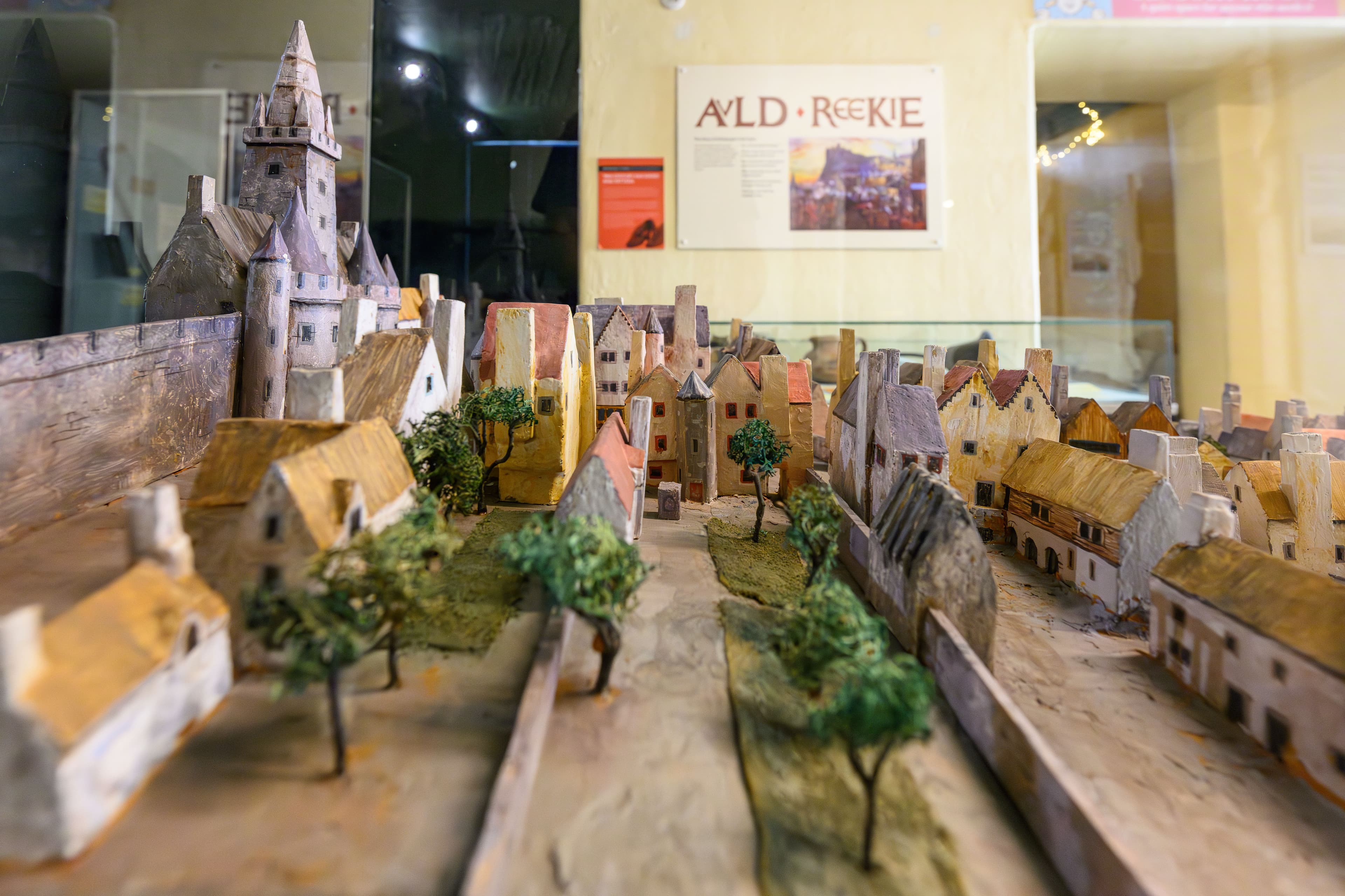 A scale model of a Edinburgh Old town with diverse buildings and greenery, representing an urban environment in miniature form.