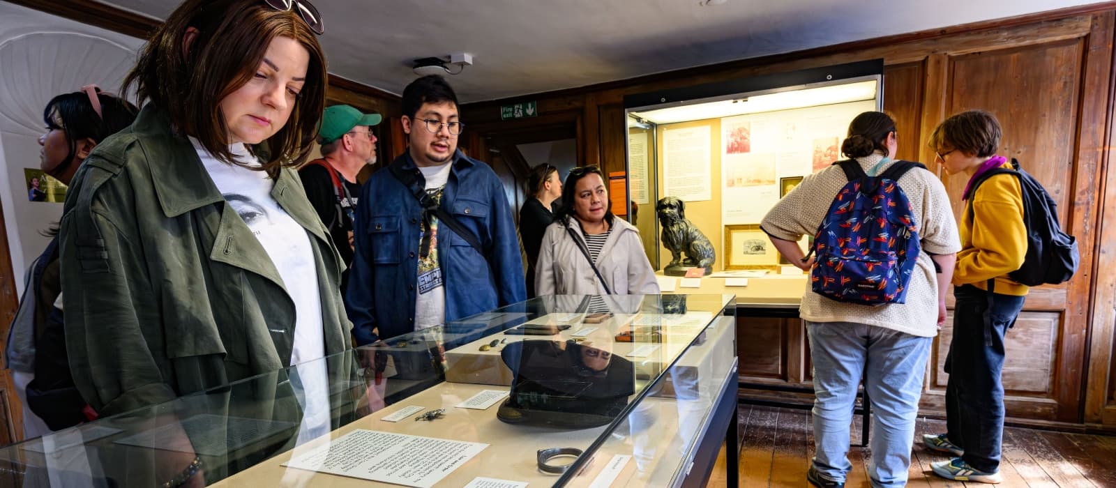 Museum-goers engaged with a display of artifacts, showcasing cultural history.