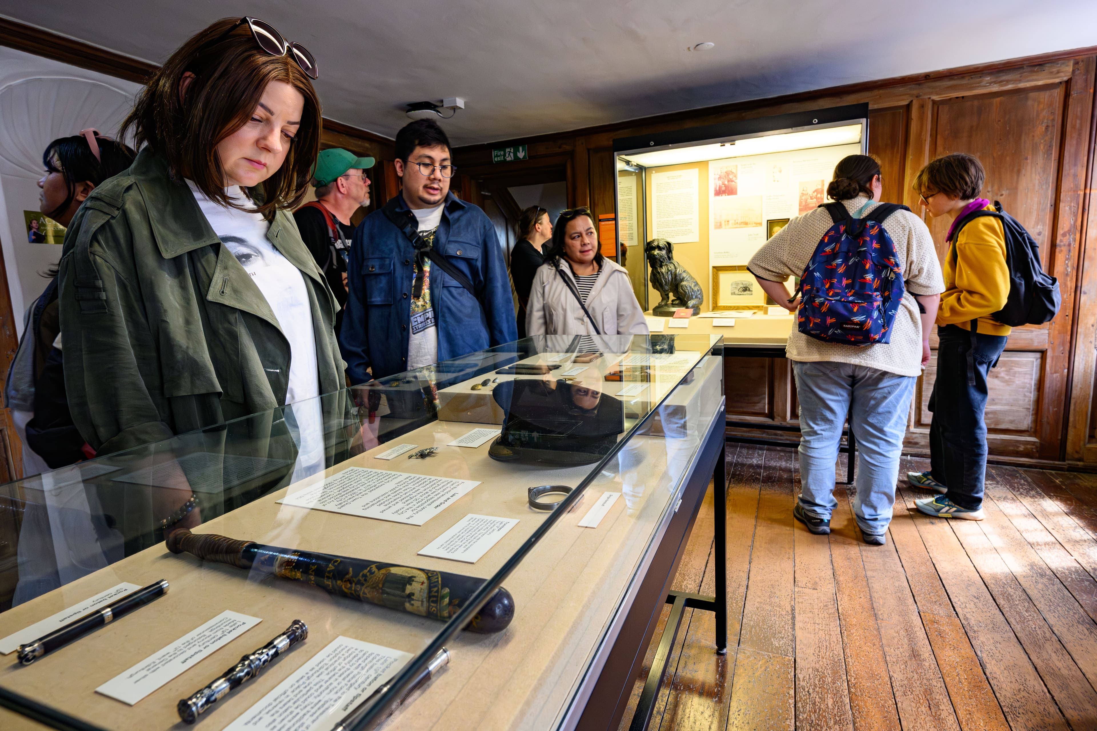 Museum-goers engaged with a display of artifacts, showcasing cultural history.