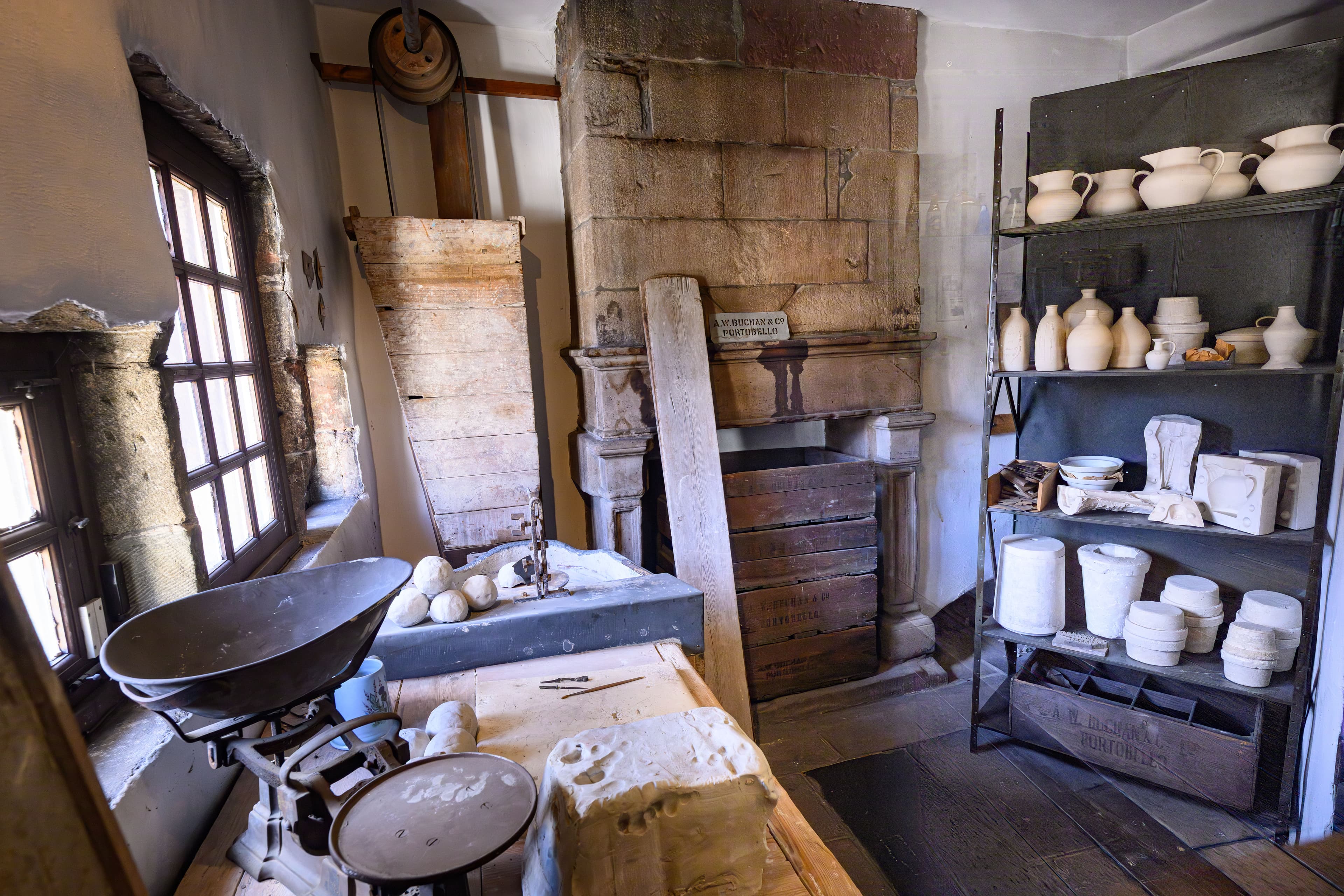 A charming room showcasing a fireplace, adorned with a variety of pots and pans displayed on shelves and walls.