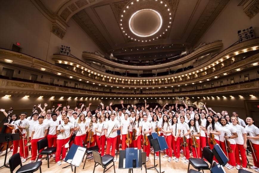 NYO2 standing on the stage wearing red and white