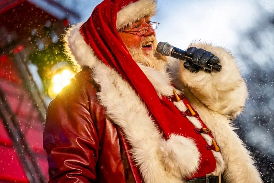 A man dressed as Santa holding a microphone