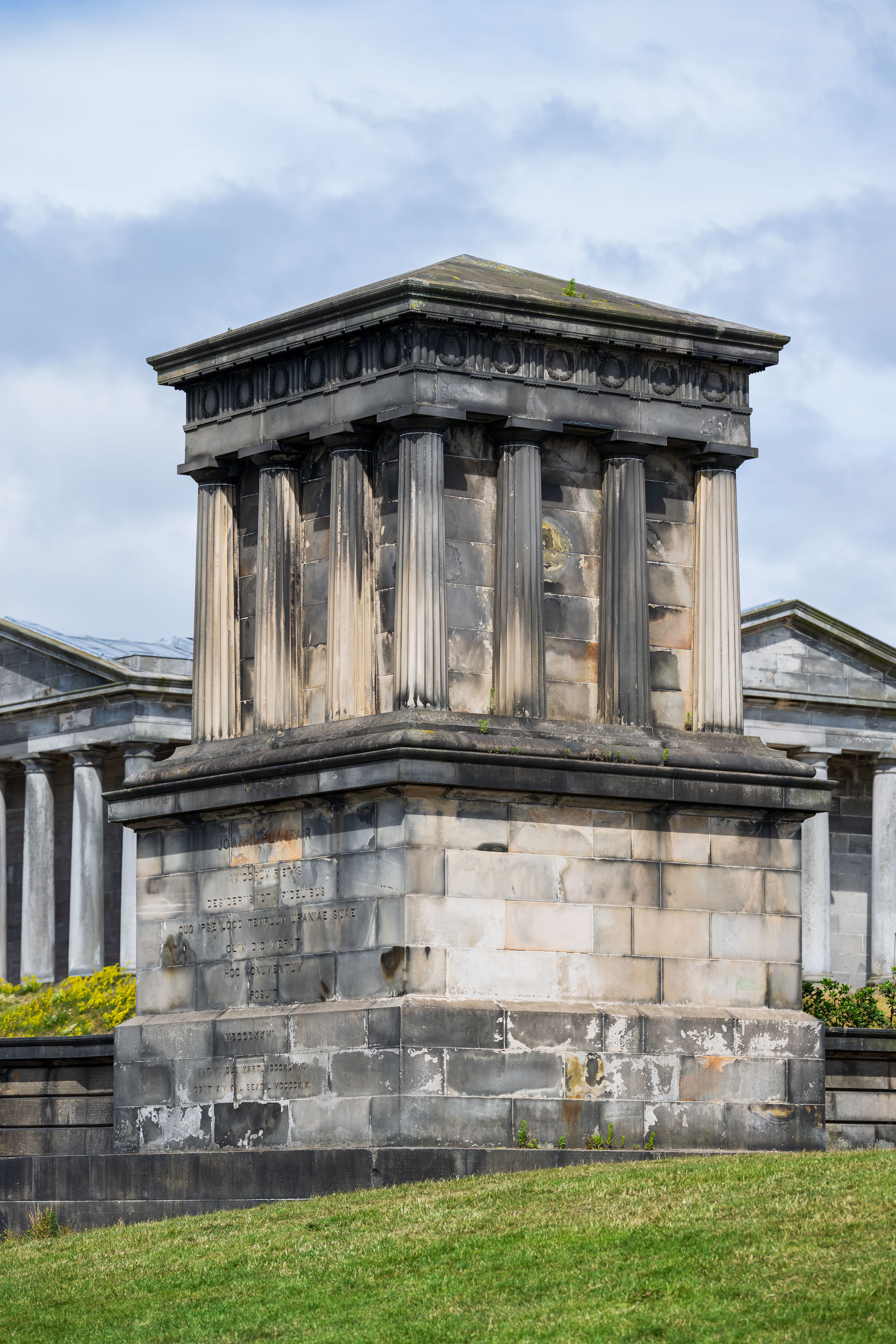 A Roman style monument with columns on a cloudy day