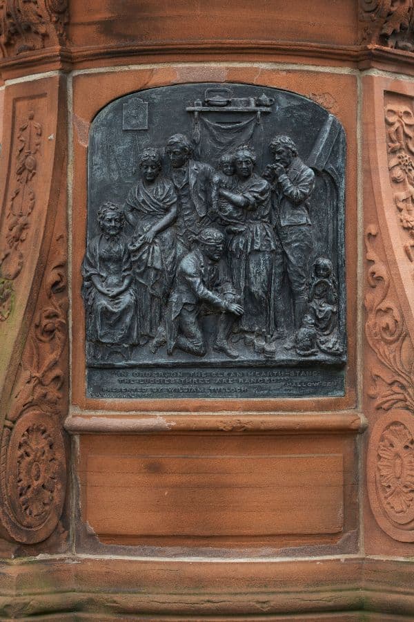 Engraving of a group of people on the side of a statue