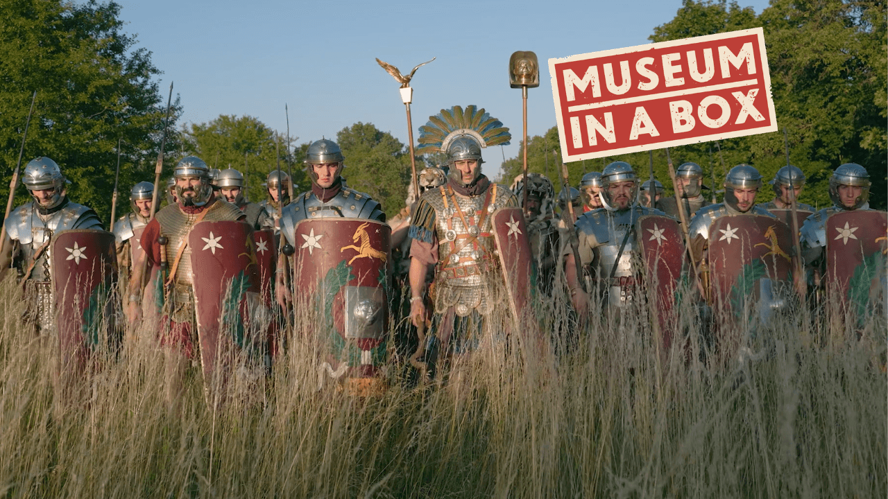 Men in Roman battle costume standing in a field