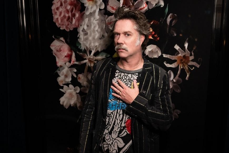 Rufus Wainwright wearing striped suit jacket and tshirt