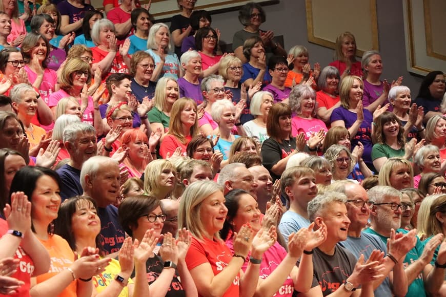 Sing in the city choir on stage singing 