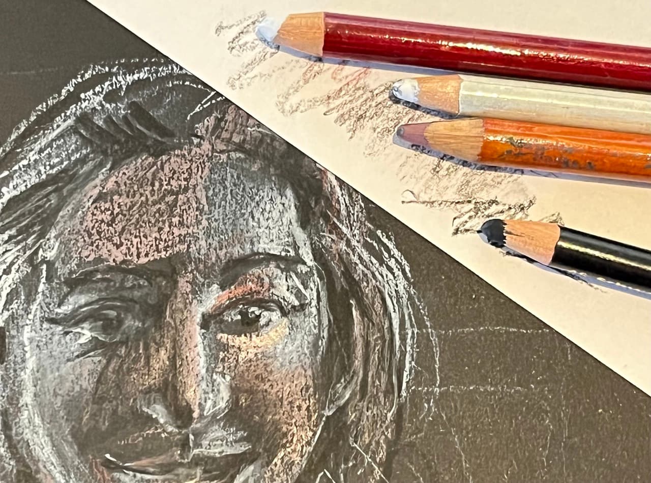 Face drawn in pastels on black paper