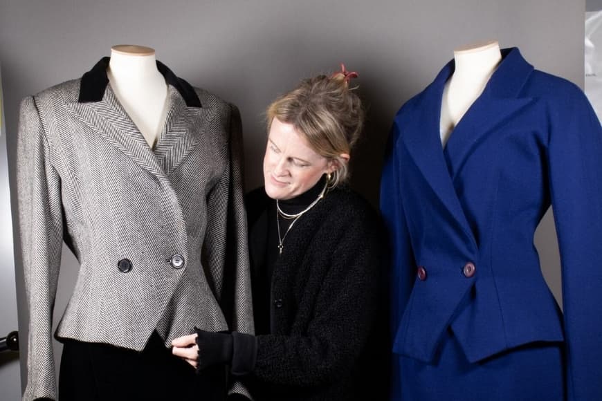 Curator adjusting vintage jackets on tailor's dummy