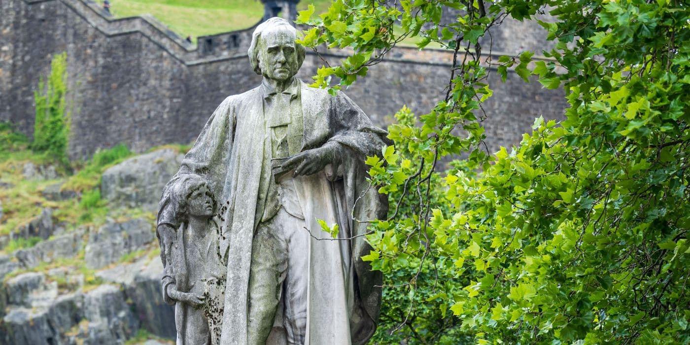 White statue of an older man holding a child by his side