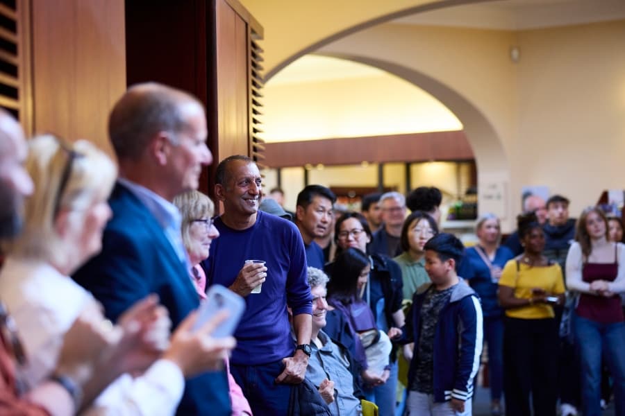 Group of people happily smiling waiting to go in to see a show