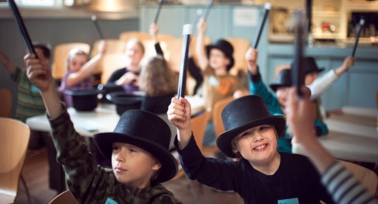 Youd boys dressed in top hats with magic wands