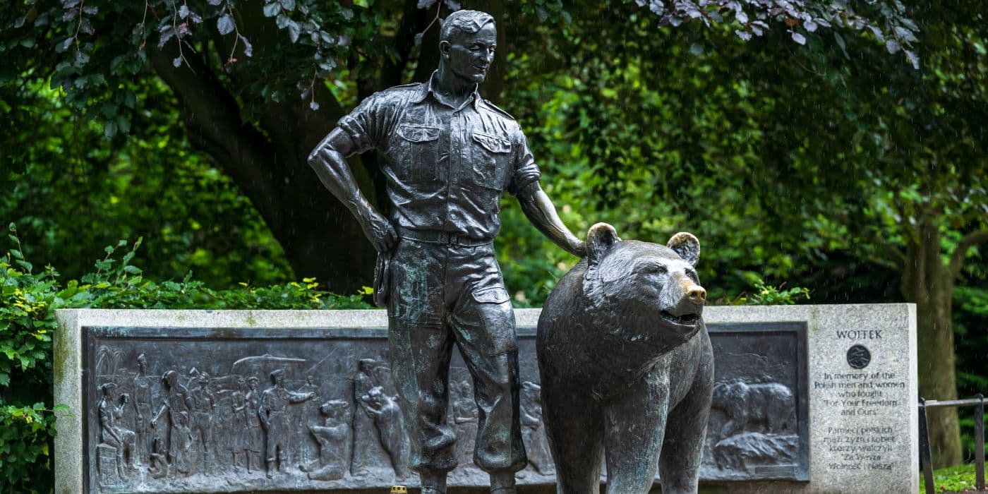 Statues of a man next to a bear