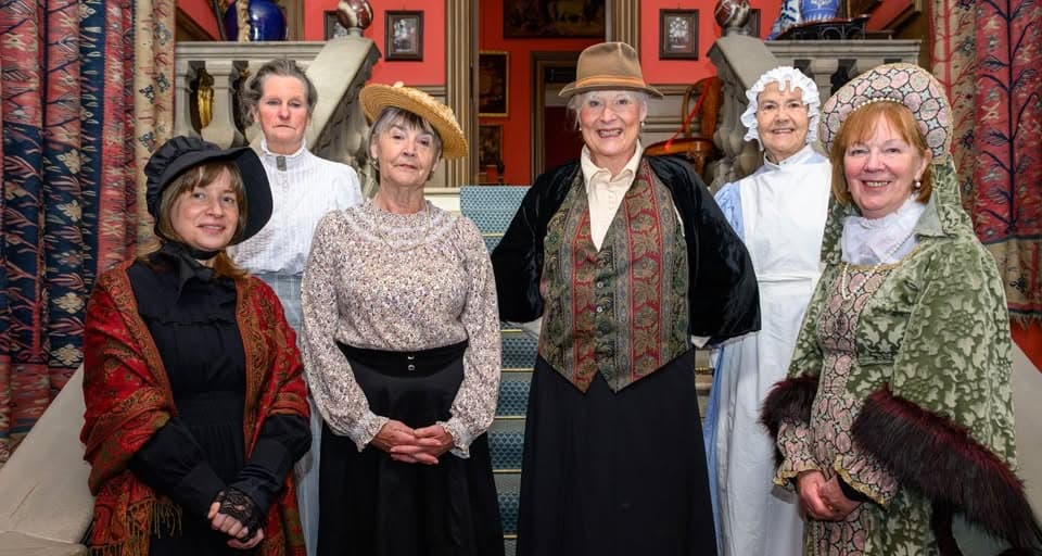 Group of women in Edwardian costume, standing on the  staircase of Lauriston Castle