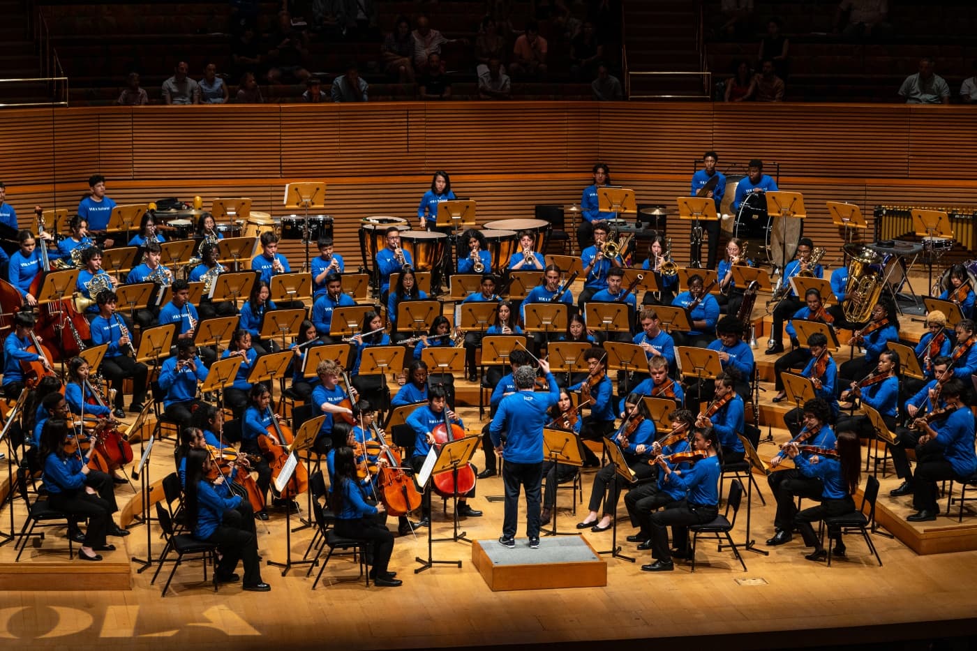 A conductor leads a group of young musicians performing as part of an orchestra. Part of the Edinburgh International Festival 2026