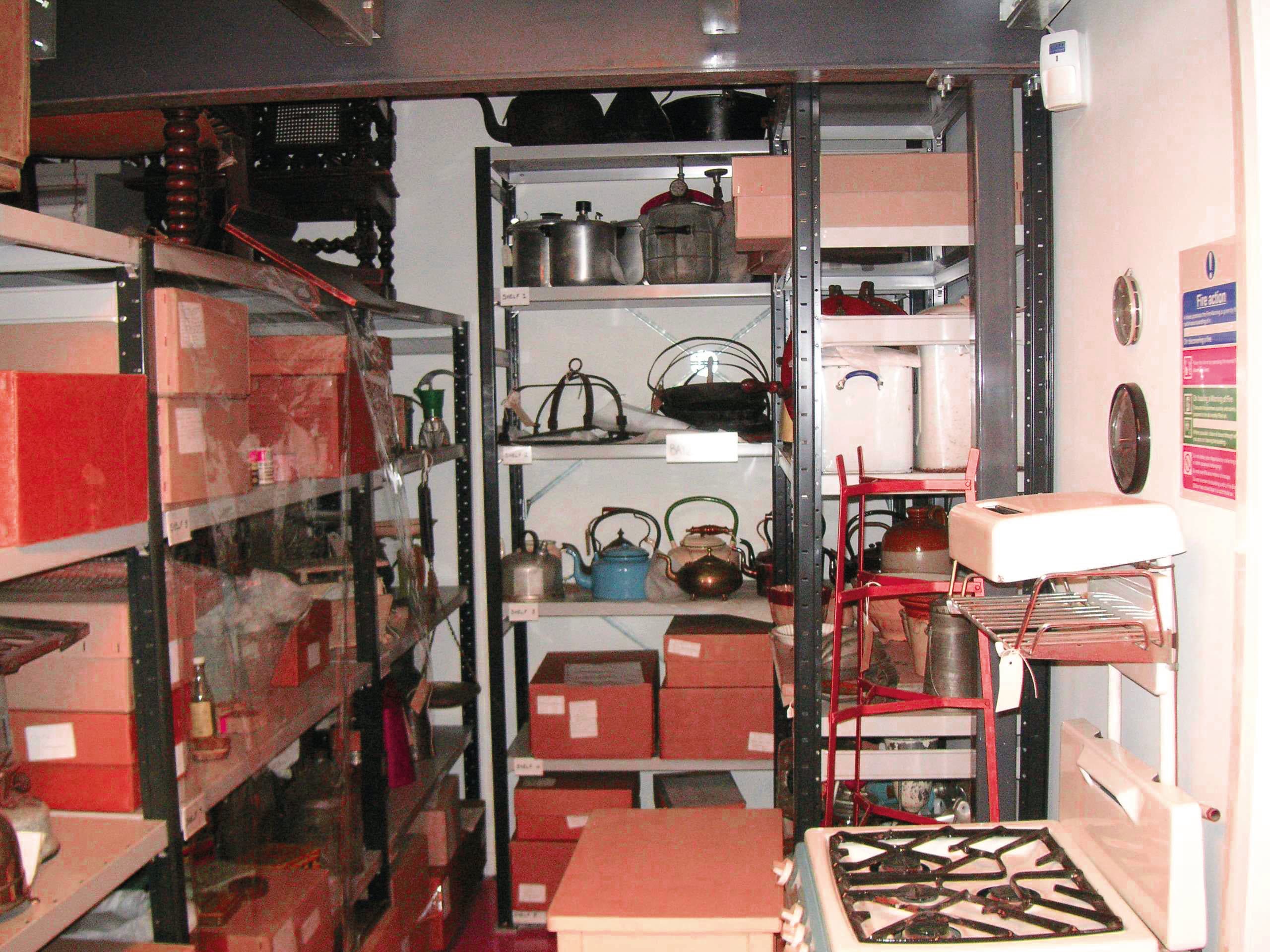A store room filled with various pots and pans neatly arranged on shelves, showcasing a well-organized storage space.