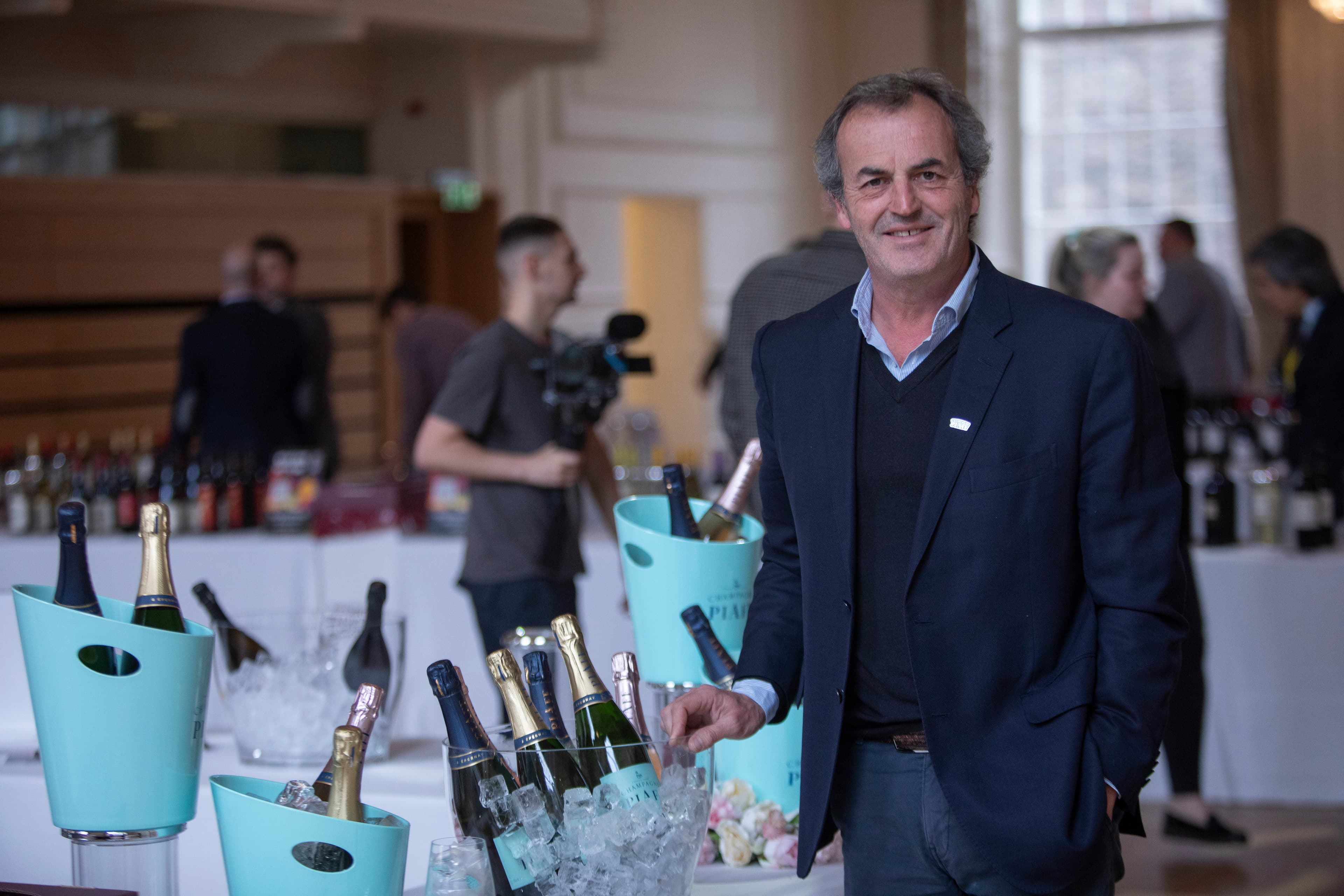 Gentleman stood with wine bottles in the Music Hall.