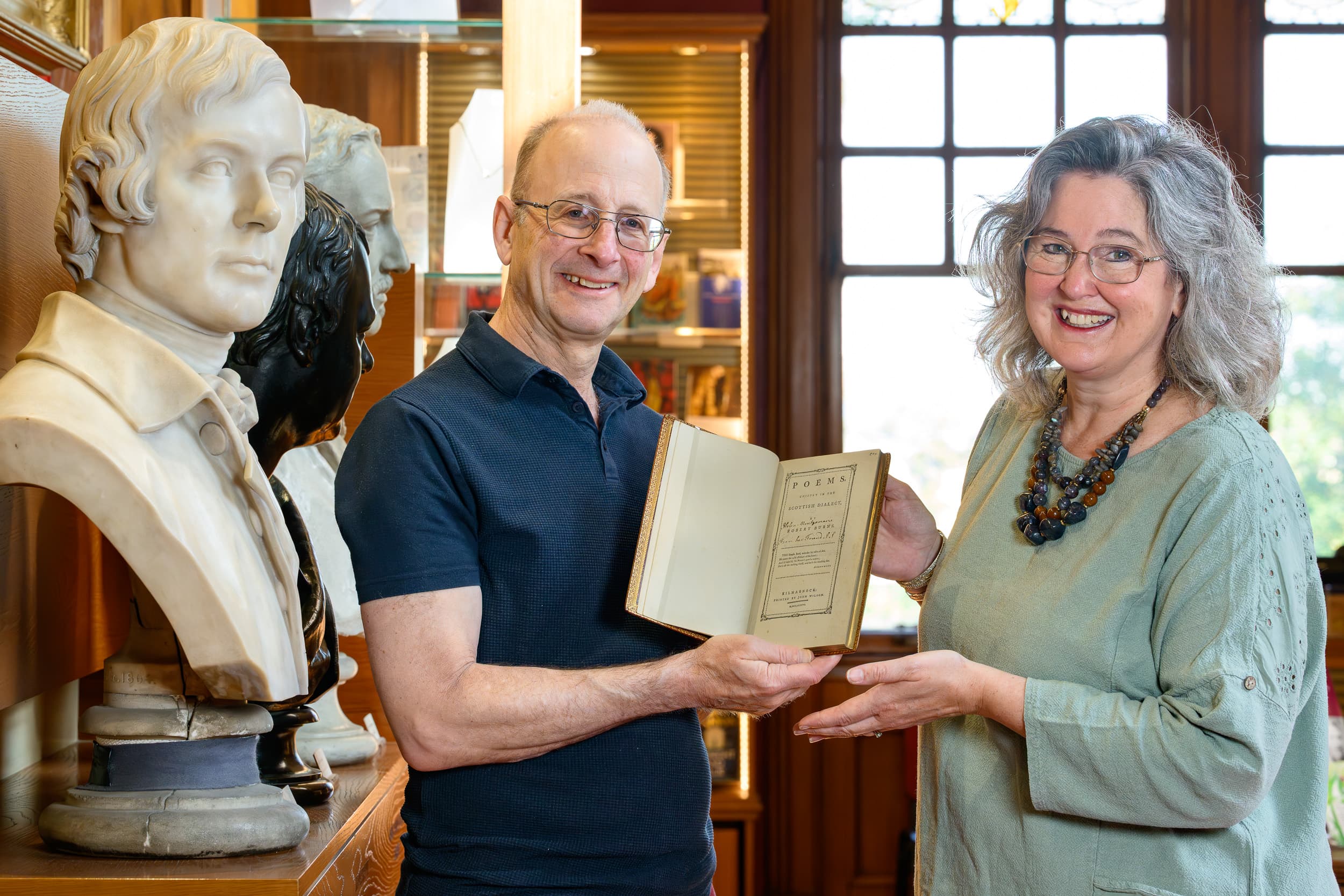 Man and woman holding Burns' Kilmarnock edition book