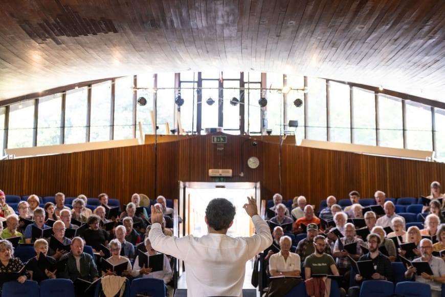 Man in white shirt conducting choir