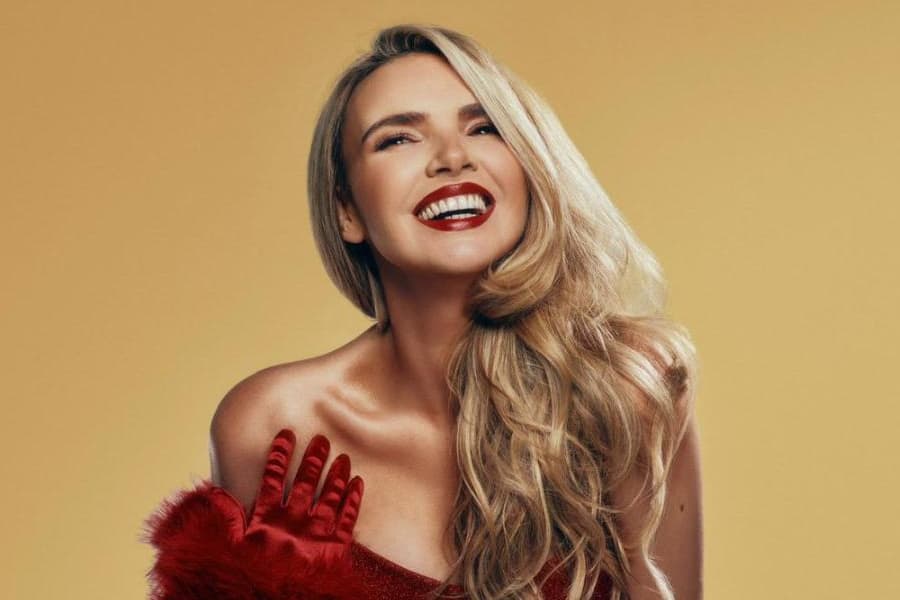 A photo of a blonde woman in a red Christmas outfit