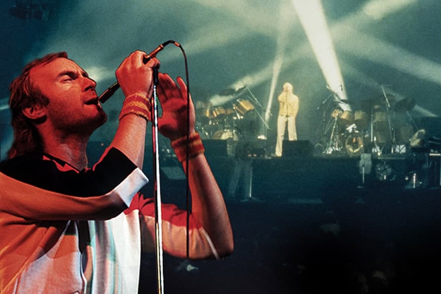 Phil Collins singing into a microphone