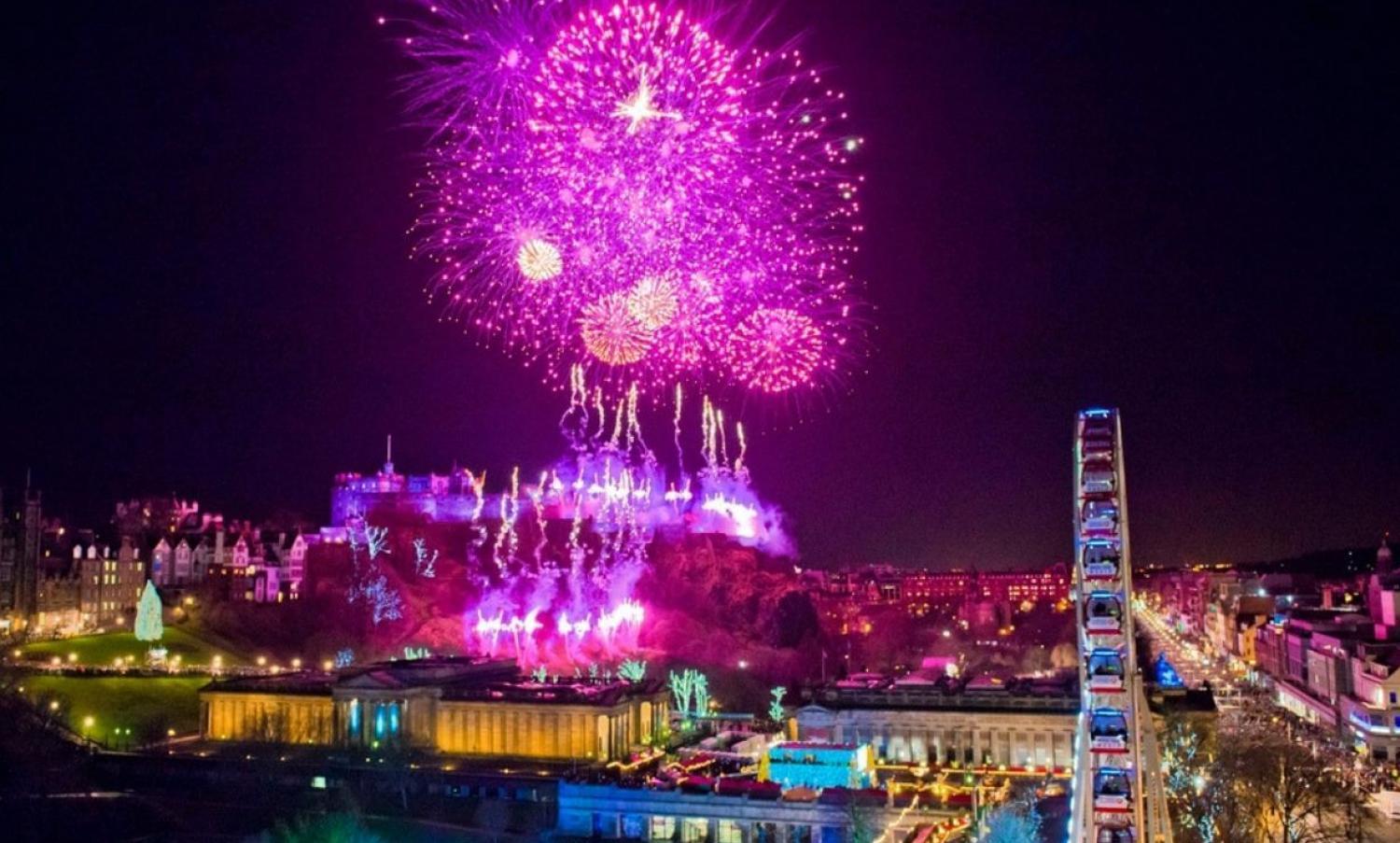 Purple fireworks above Edinburgh Castle and Big Wheel at Edinburgh's Hogmanay