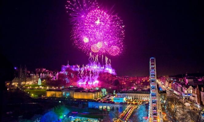 Hogmanay fireworks over Edinburgh Castle and the Big Wheel in Princes Street Gardens.